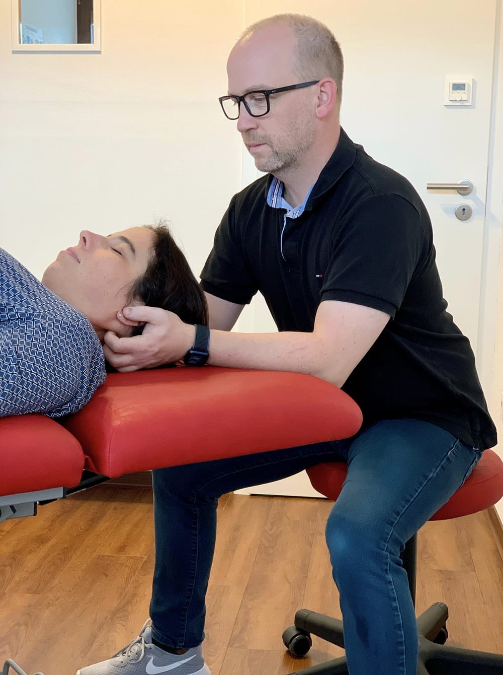 Tobias Kern behandelt eine Patientin an der Halswirbelsäule